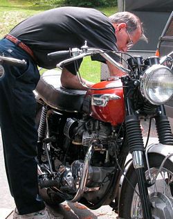 Photo of a mechanic tuning the carbs on a Triumph Bonneville motorcycle